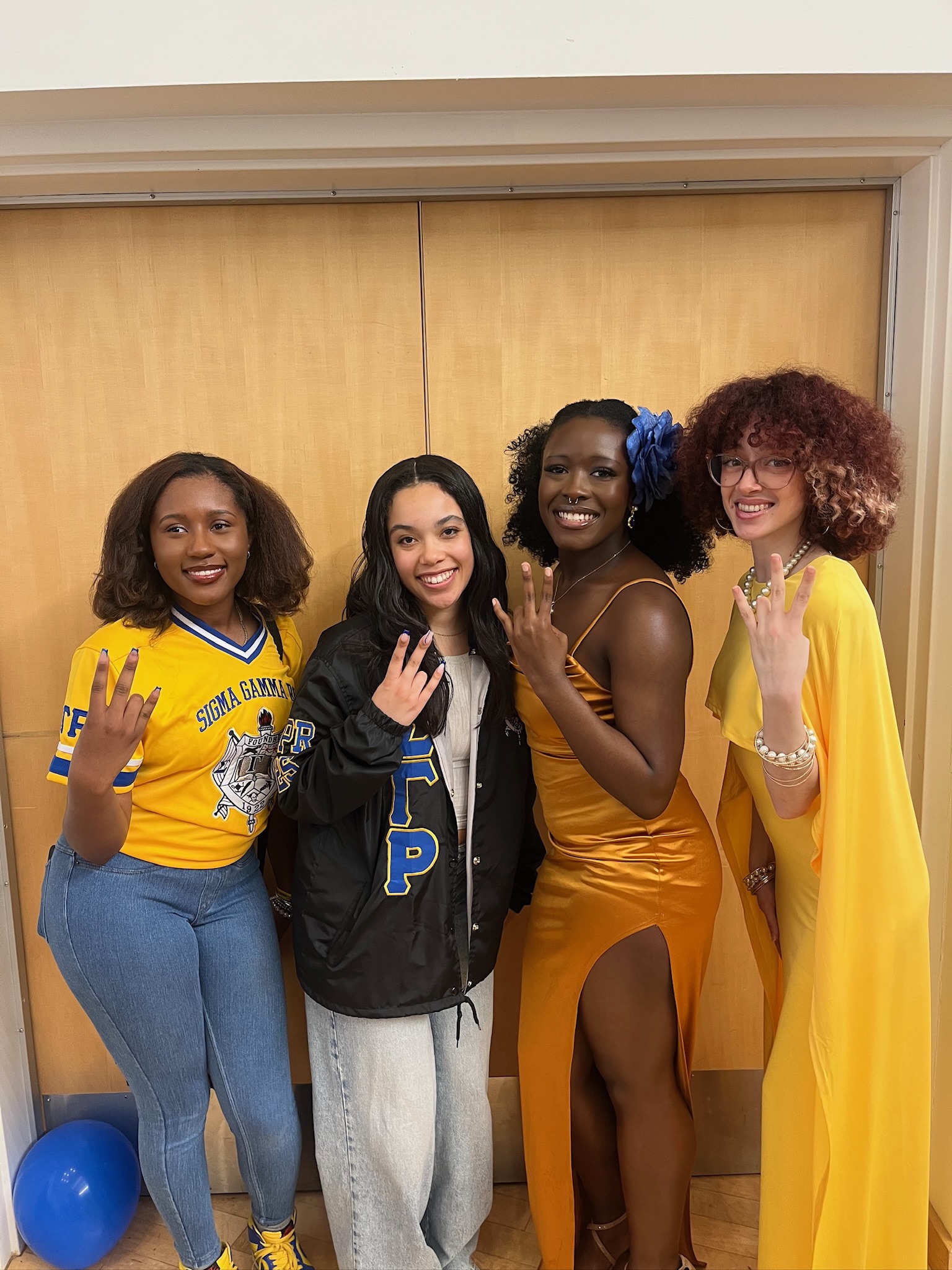 Eta members in polished royal blue and gold attire
